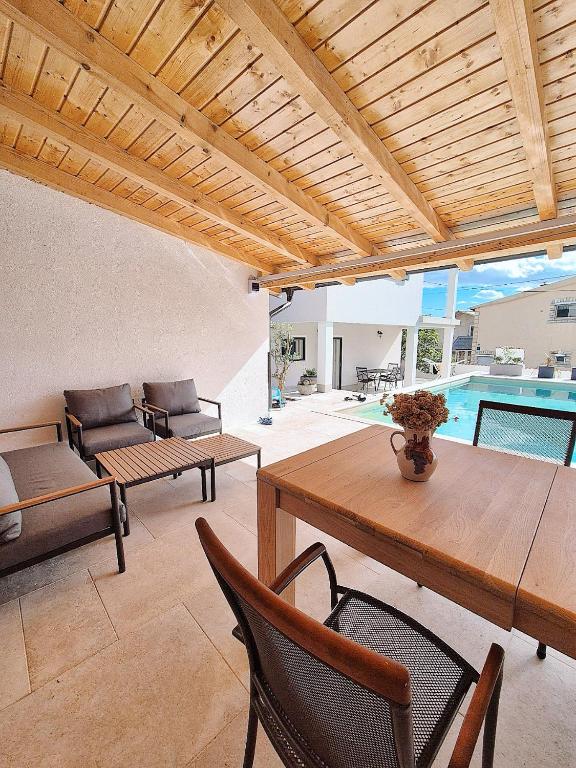 a living room with a table and chairs and a pool at Mare`s Private House 1st floor with Pool in Karlobag