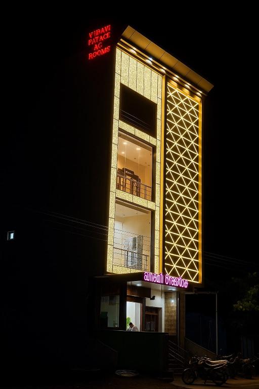 a building with a balcony and a sign on it at Vasavi Palace Residency in Pennāttūr