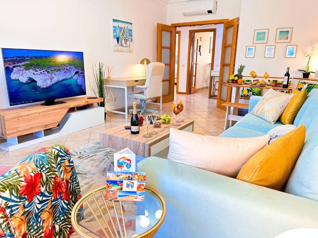 un soggiorno con un divano blu e una TV di Golden Palm Condo by BeCherish ad Albufeira