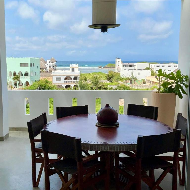a dining room table with chairs and a view of the ocean at Luxury Penthouse 7 Islands View at Ocean Pearls in Watamu