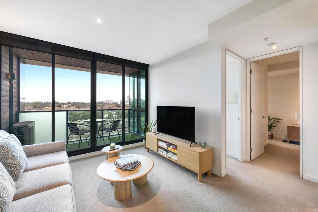 a living room with a couch and a tv at 108 Flinders - Stunning Views & Prime Location in Melbourne