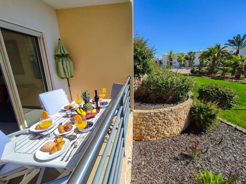 een tafel met borden eten op een balkon bij AlbufeiraOrada Garden by Be Cherish in Albufeira