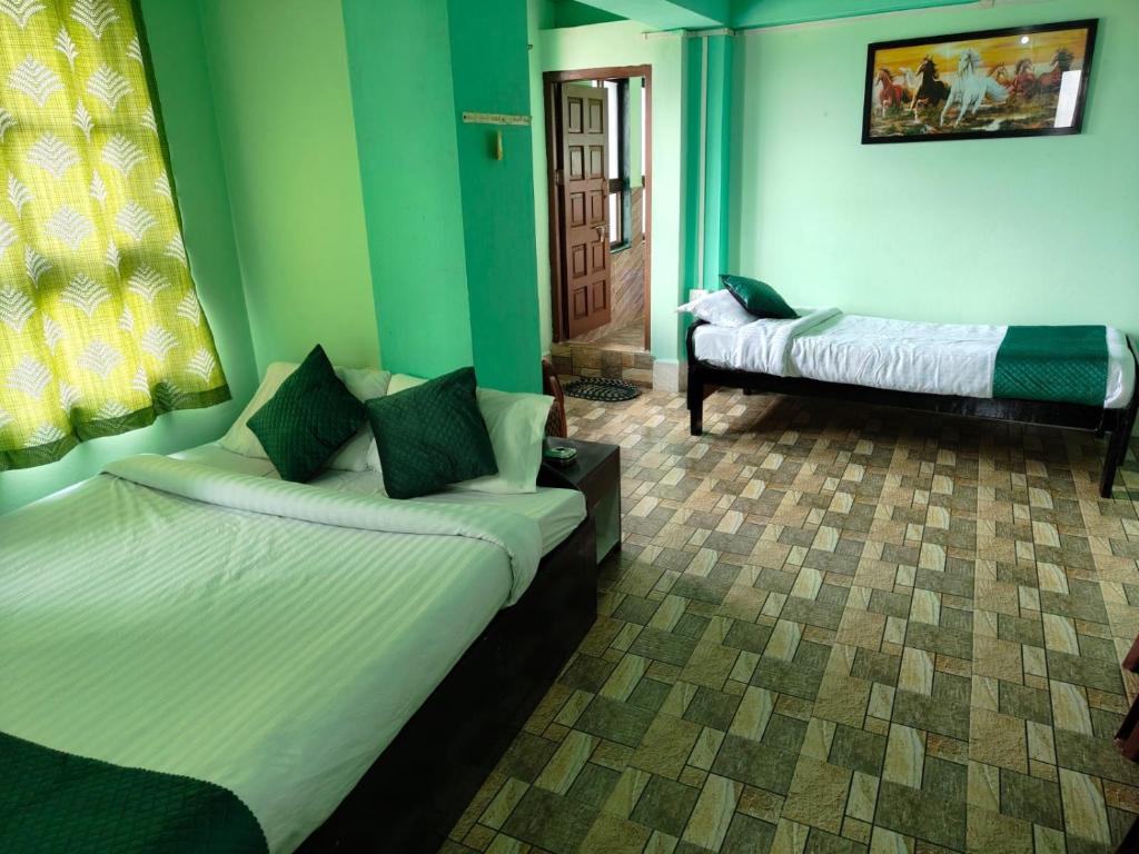 una camera con due letti e un divano in esso di Our Villa Guest House a Shillong