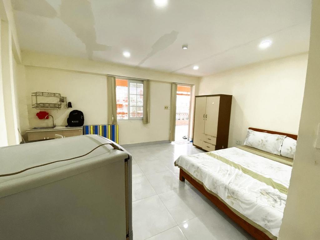 een slaapkamer met 2 bedden en een keuken. bij Vina Home in Ho Chi Minh-stad