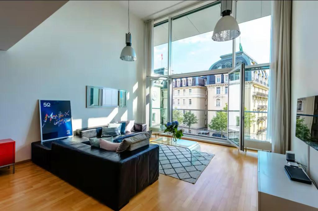 a living room with a couch and a large window at Montreux Stunning 2 Bedroom Apartment Lake Geneva in Montreux