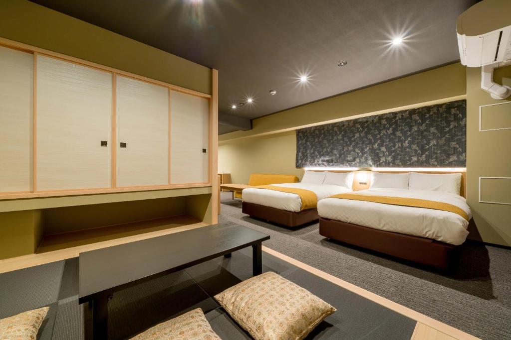 een hotelkamer met twee bedden en een bank bij RESI STAY ANDON in Kyoto