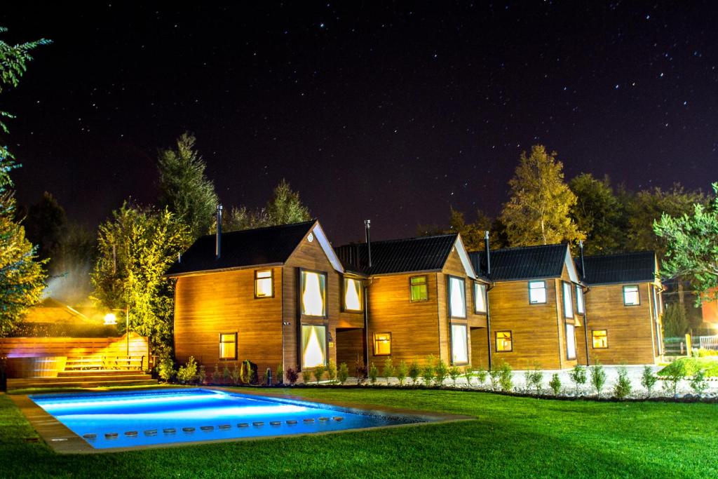 una casa por la noche con piscina en Complejo Buenavista Pucon, en Pucón