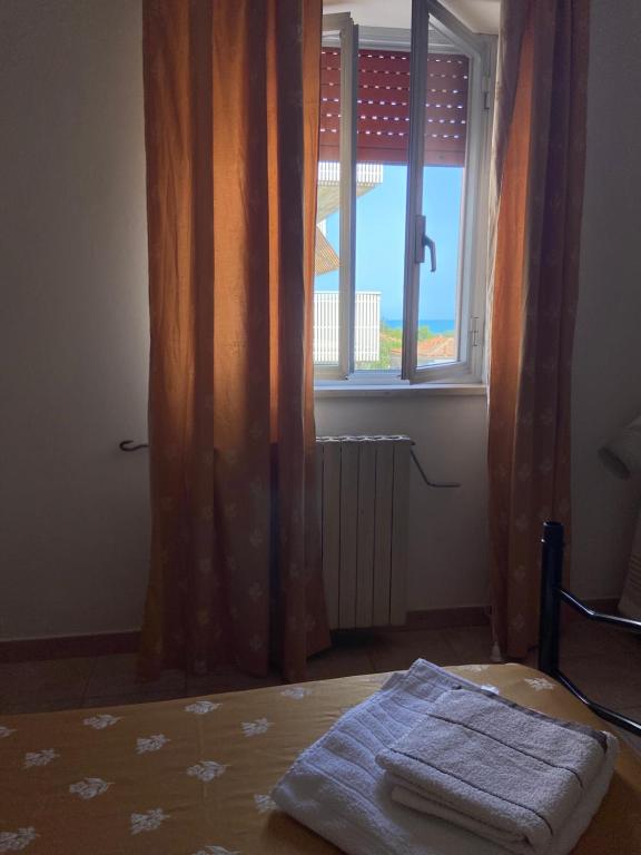 a bedroom with a bed and a window with curtains at L'Ostello in Vasto