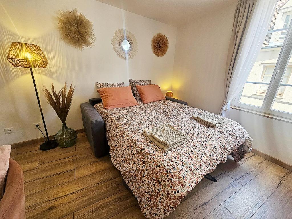 ein Schlafzimmer mit einem Bett mit orangefarbenen Kissen darauf in der Unterkunft Maison de ville Chaleureuse au cœur de Chartres Netflix, garage vélos in Chartres