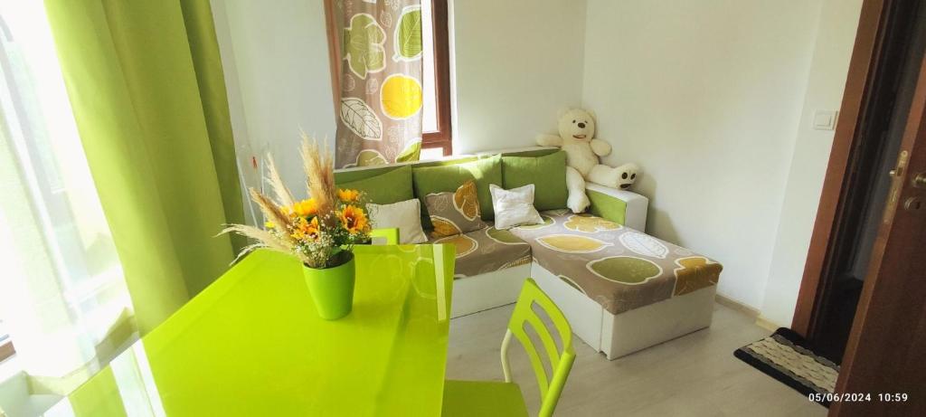 a living room with a green couch and a table at Къща Поморини Несебър in Nesebar