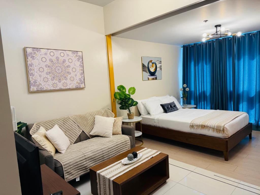 a living room with a bed and a couch at Modern Suite In Bonifacio Global City in Manila