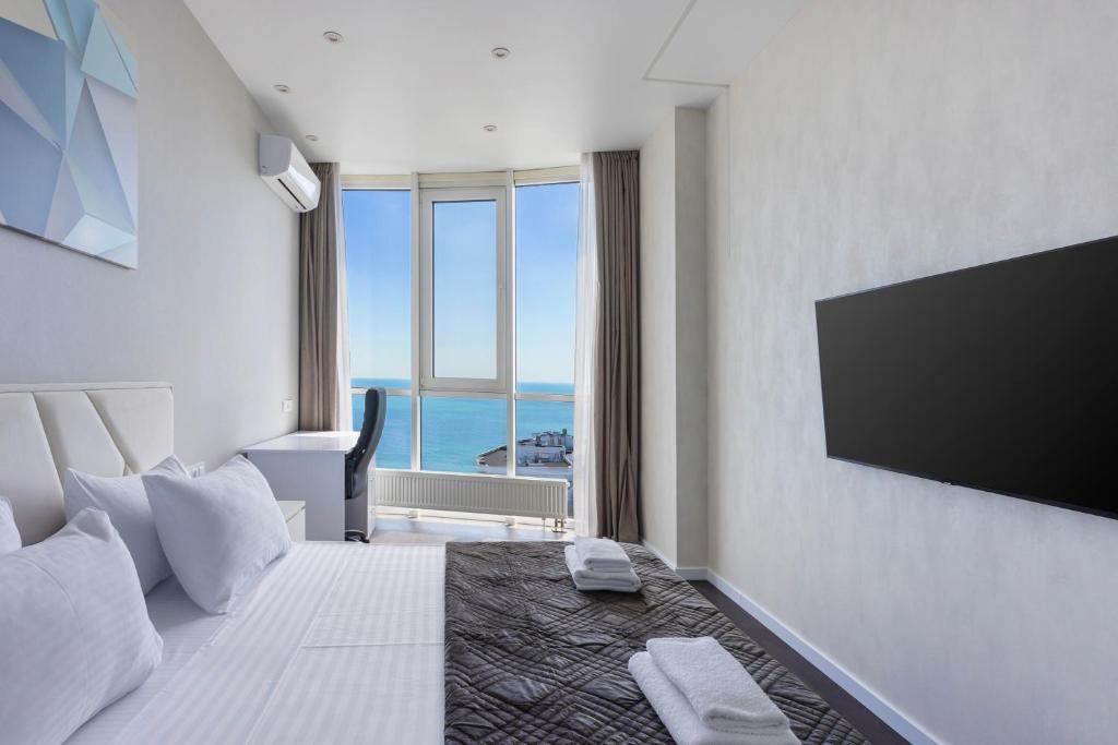 a hotel room with a large bed with a flat screen tv at Sea Pearl 1Line in Odesa
