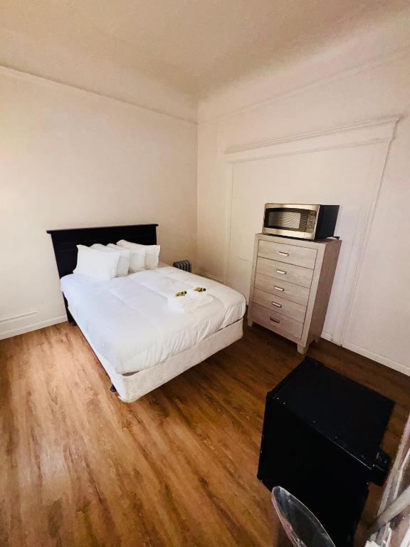 a bedroom with a white bed and a microwave at Riviera Hotel in San Francisco