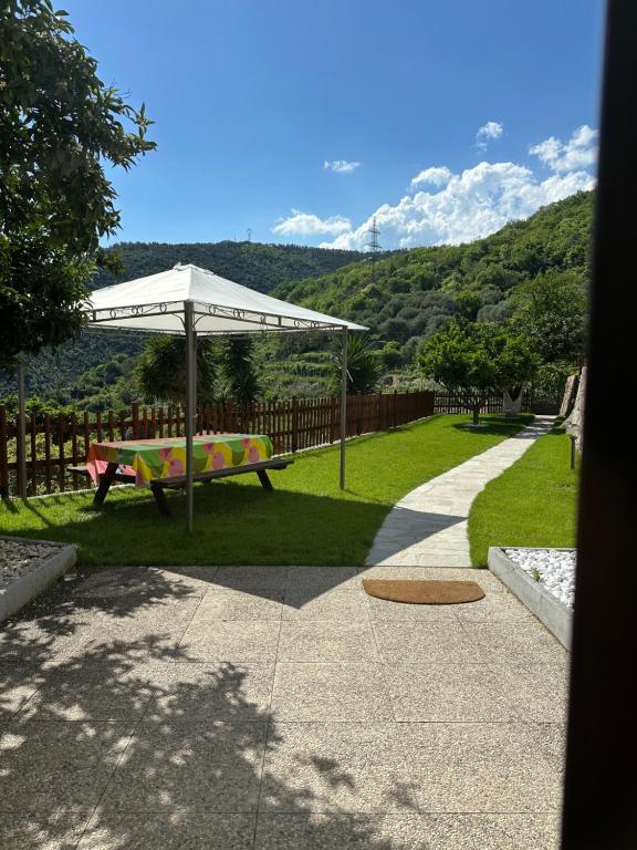 a picnic table under an umbrella in the grass at Cà Raffa - The Oasis of Peace in Ranzi