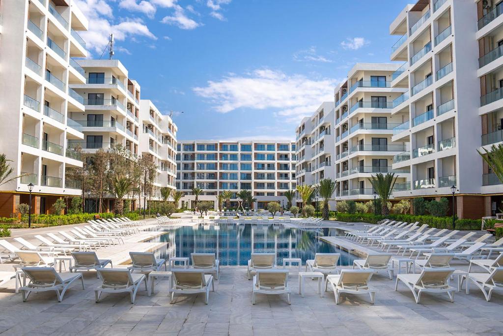 a swimming pool with lounge chairs in front of a building at Seabreeze in Baku