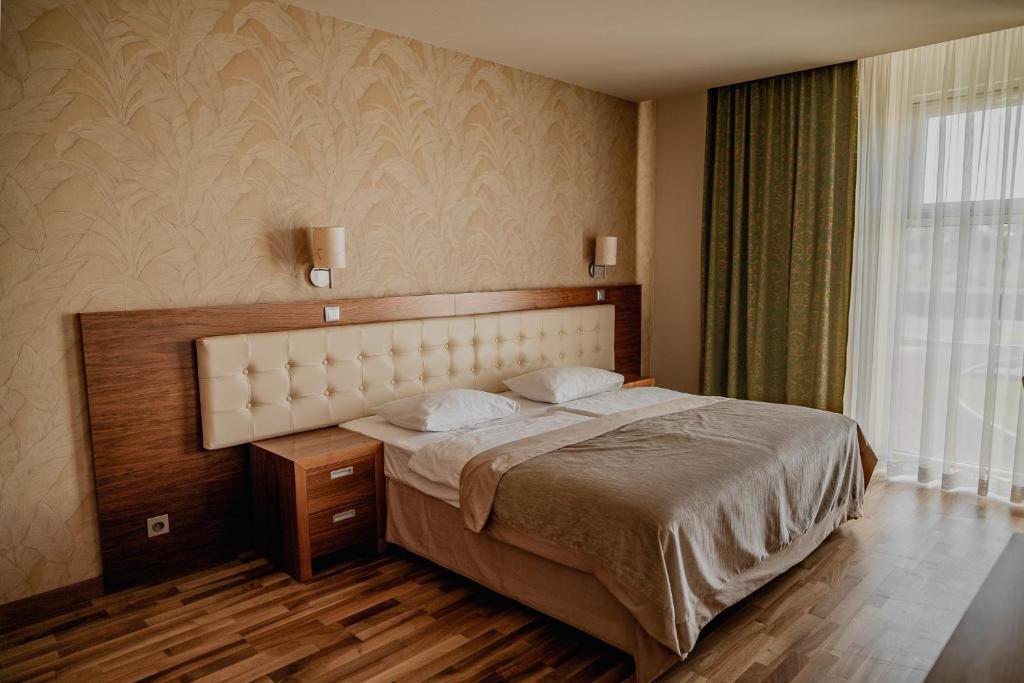 a bedroom with a large bed and a window at Apartament 125 w Hotelu Platinum in Ostróda
