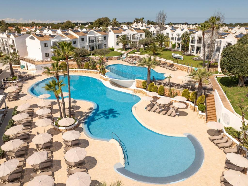 an aerial view of a resort swimming pool with umbrellas at MarSenses Paradise Club in Cala en Bosc