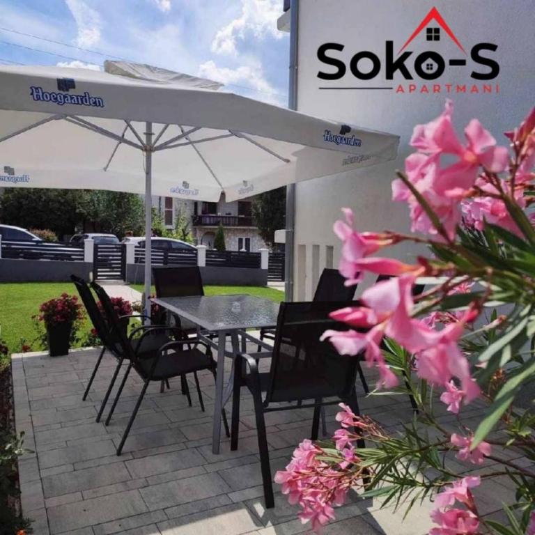 a patio with a table and chairs and an umbrella at Soko S apartmani in Soko Banja