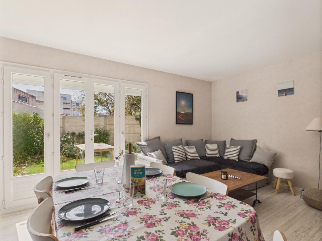 un salon avec une table et un canapé dans l'établissement 100m de la plage - Maison pour 4 à St Hilaire, à Les Bussolleries