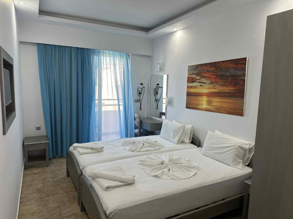 a bedroom with a large bed with white sheets at Oceanis Hotel in Karpathos