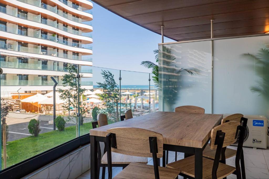a dining room with a table and chairs and a large window at De Silva Apartament1 in Mamaia