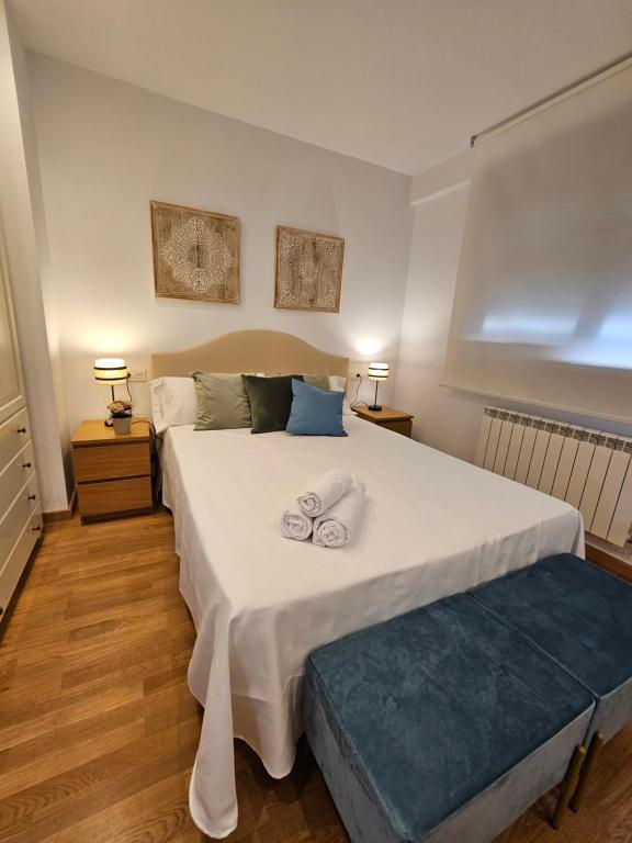 a bedroom with a large bed with two towels on it at Casa Entre Viñas, jardin privado con piscina comunitaria in Uruñuela