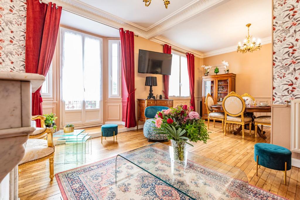 a living room with a vase of flowers on a table at Le Louis XV Halte à Reims centre in Reims