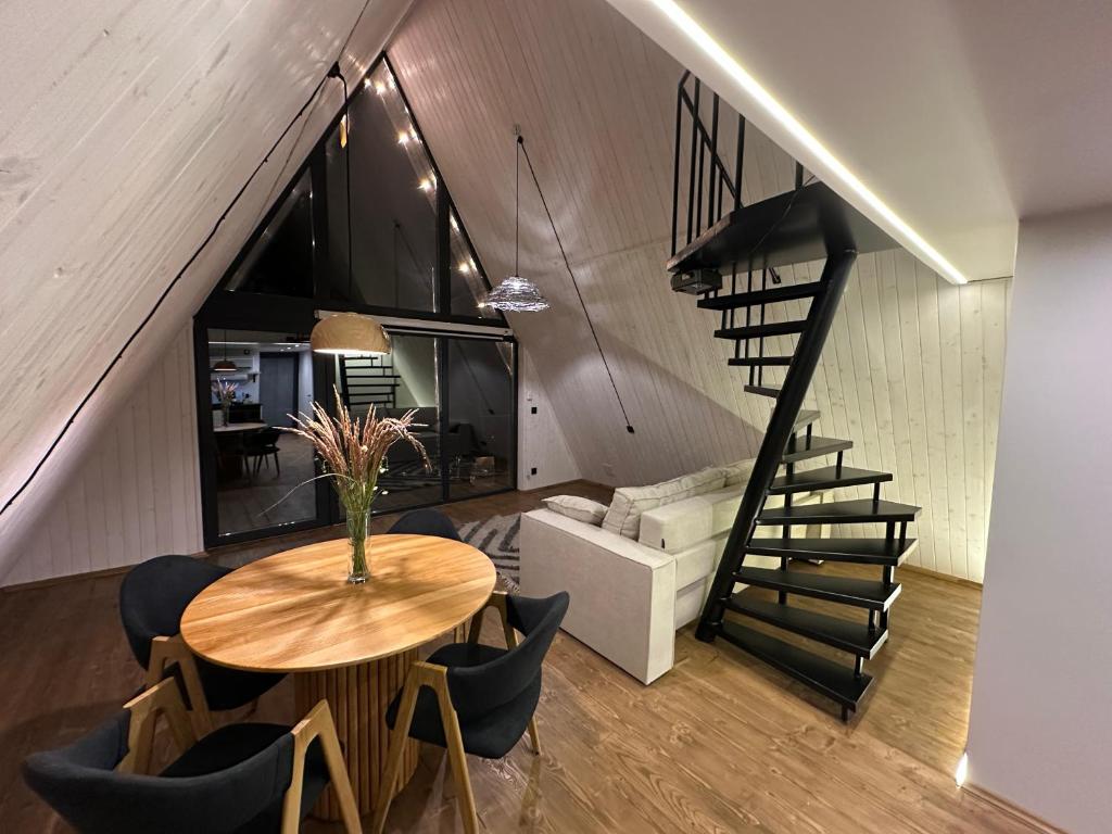 a room with a table with chairs and a staircase at Greenkova in Kamenitsa