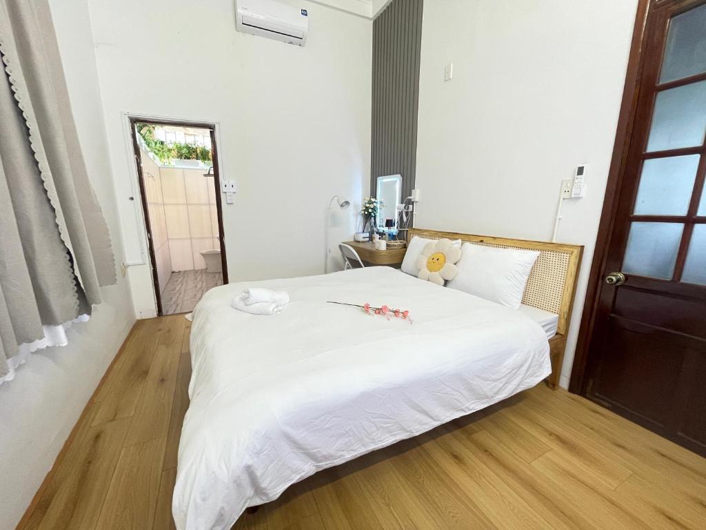 Champagne Homestay في هوى: غرفة نوم بها سرير أبيض وعليه زهور