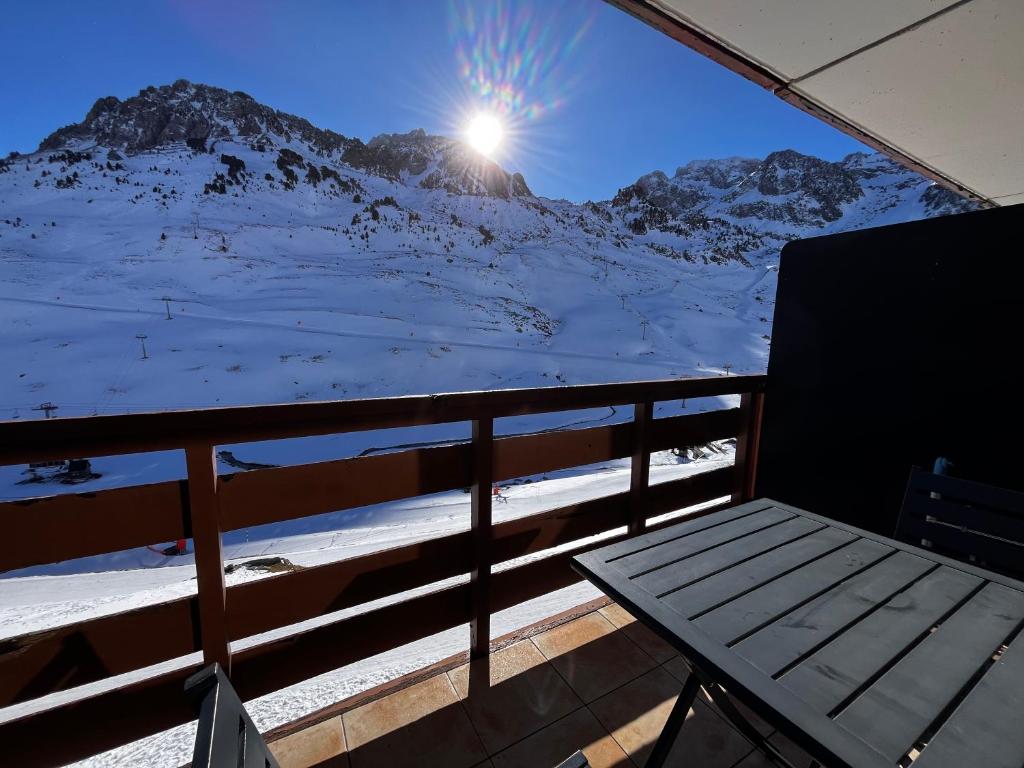 una panchina su un balcone con una montagna innevata di Studios au pied des pistes , La Mongie Tourmalet, balcon plein Sud a La Mongie