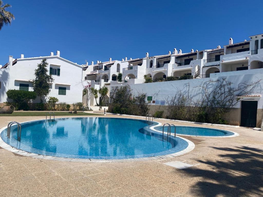 een groot zwembad voor een gebouw bij C-4 by SOM Menorca in Son Parc