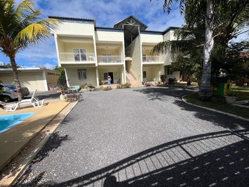 a house with a driveway and a swimming pool at Pointe Aux Biches Villa in Pointe aux Biches