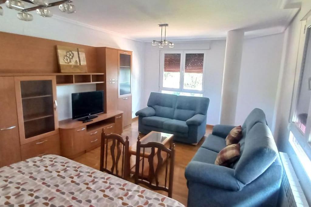 ein Wohnzimmer mit einem blauen Sofa und einem Sessel in der Unterkunft Apartamentos vacacionales La Vega Briviesca in Briviesca