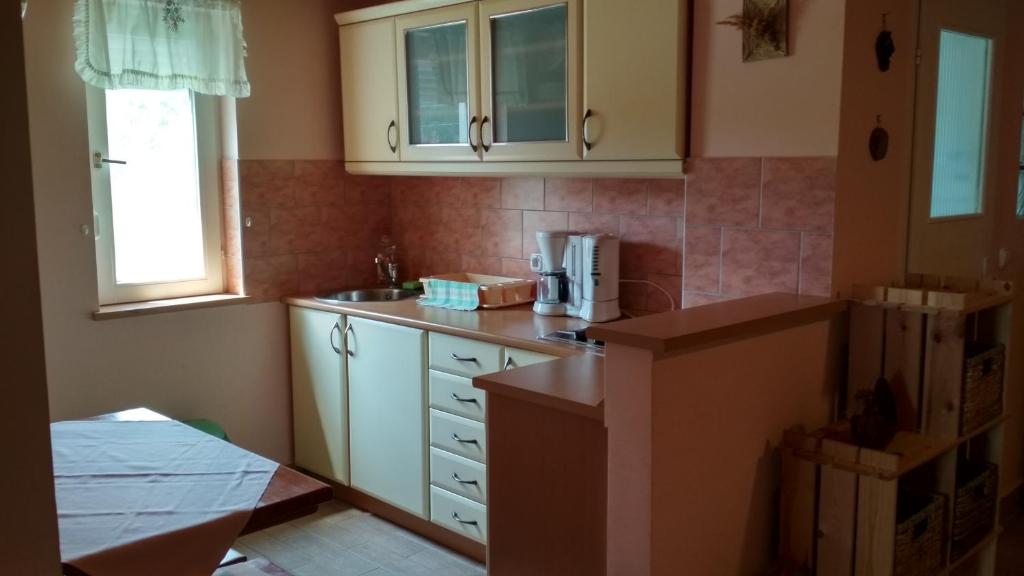 a kitchen with white cabinets and a counter top at Kati Appartmann in Balatonberény