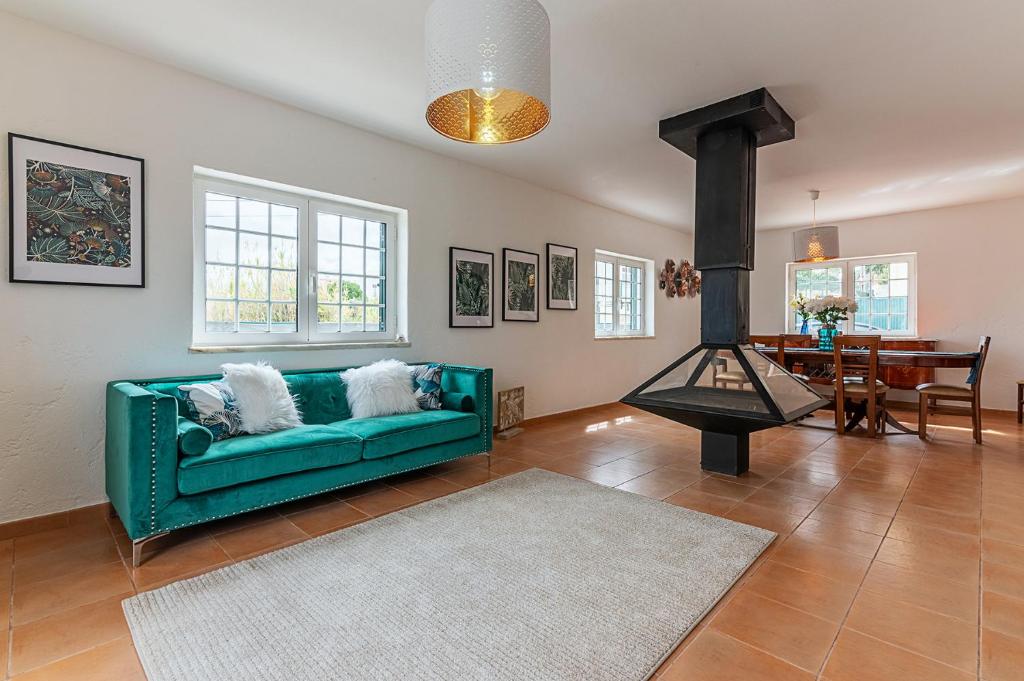 a living room with a green couch and a table at Marmeleira Country House in Carregado