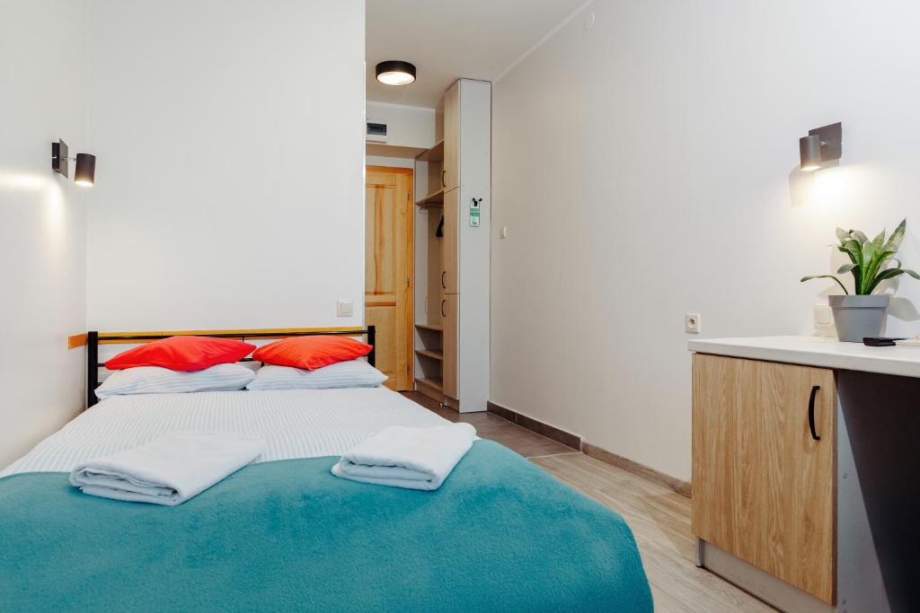 a bedroom with a bed with two towels on it at Arcus Premium Hostel in Warsaw