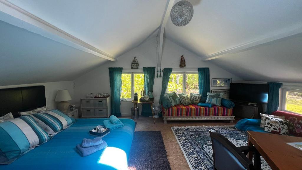 Una sala de estar con un sofá azul en un ático. en LeLoft au dessus des Pins, en Lacanau