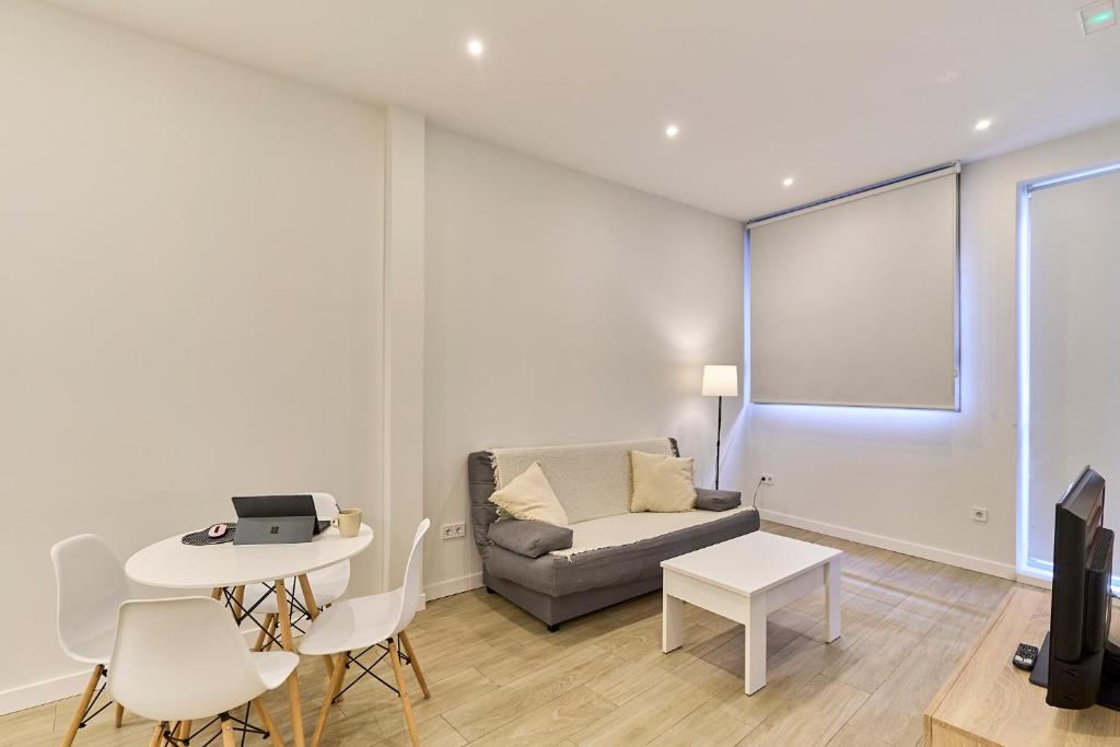 a living room with a couch and a table at Paraíso Suites by gaiarooms in Valladolid