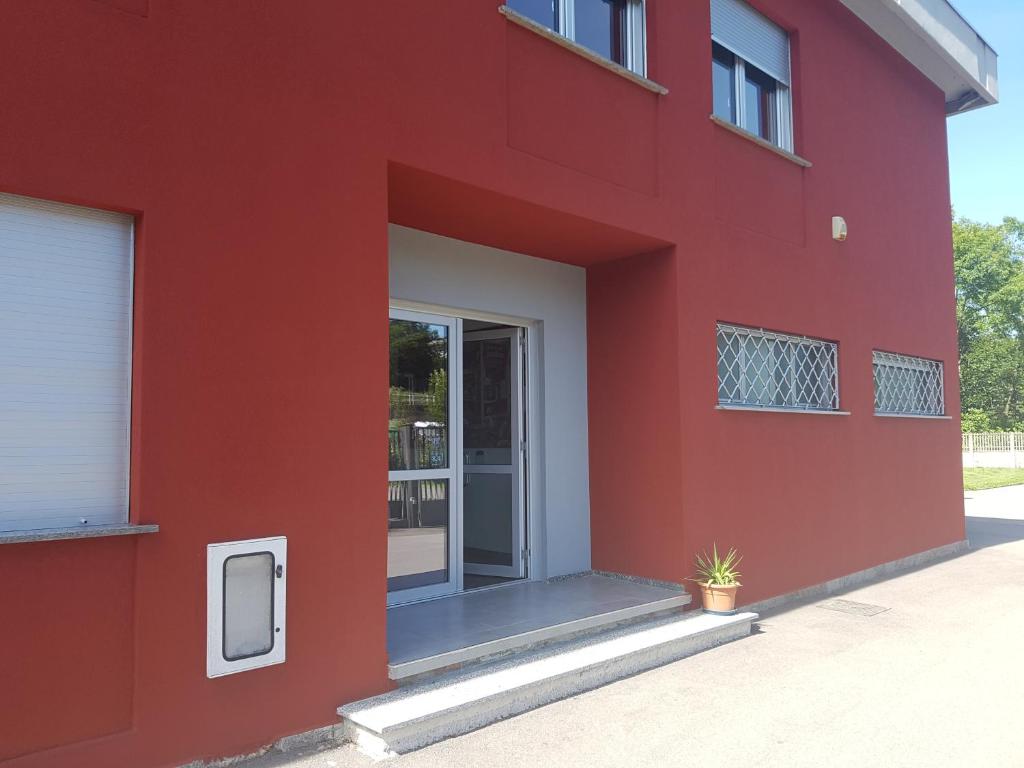 ein rotes Gebäude mit Glasschiebetür in der Unterkunft Residence Campo Rotondo in Tavernerio