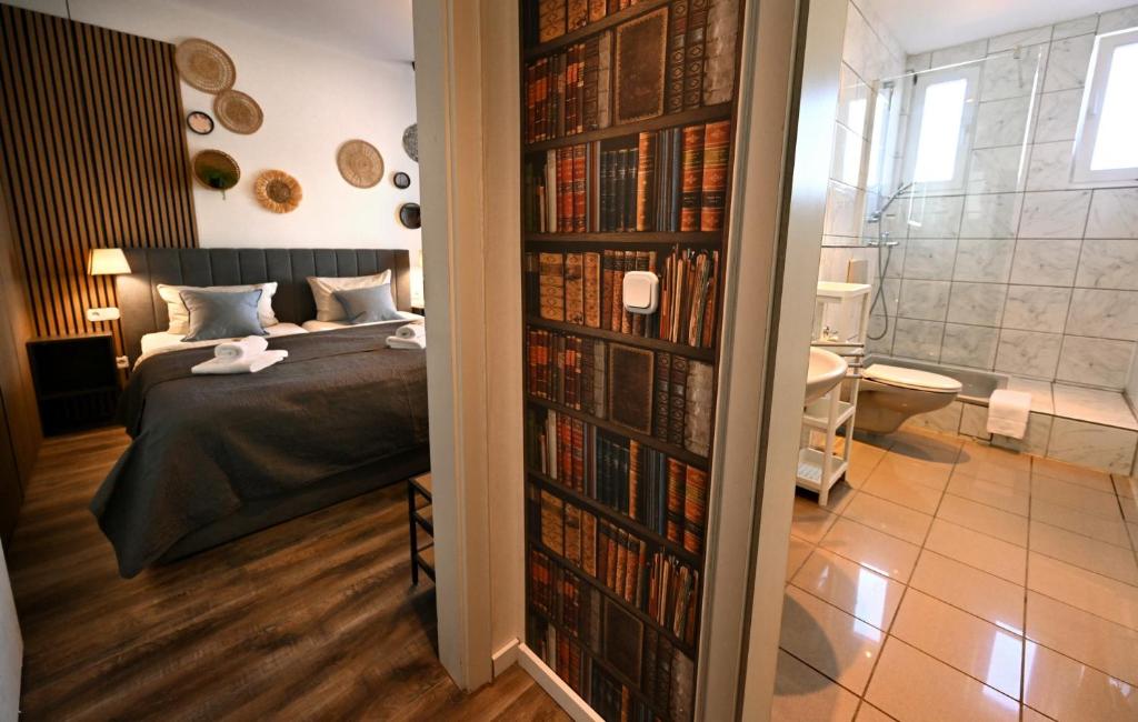 ein Schlafzimmer mit einem Bett und einem Bücherregal voller Bücher in der Unterkunft Hotel Bürgerhof in K?ln