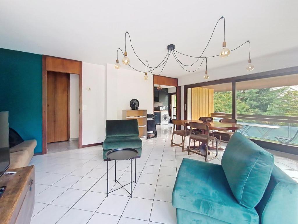 un salon avec un canapé bleu et une salle à manger dans l'établissement Cristal de Roche CI2 CALME & MOUNTAIN 8 Pers, à Châtel
