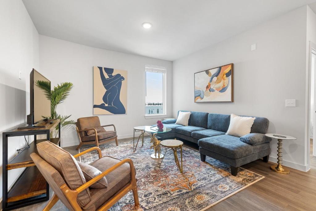 Una sala de estar con un sofá azul y sillas. en Beautiful 3 bedroom oasis close to downtown, en Austin