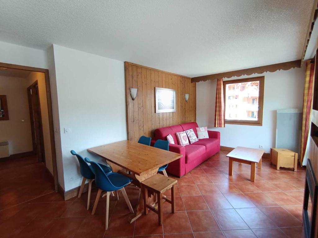 un salon avec un canapé rose et une table dans l'établissement Grand T3 plein sud avec garage couvert et accès direct aux pistes - FR-1-445-177, à Montgenèvre