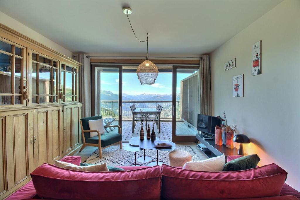 ein Wohnzimmer mit Sofa und Tisch in der Unterkunft ARC 1600, LE RIDGE, Appartement 08 personnes Vue Montagne - ski aux pieds - Sauna, Hammam, Piscine in Arc 1600