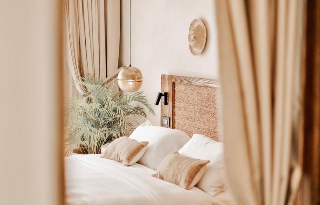 エル・アラメインにあるLe Sidi Cabanaの白いシーツと枕が備わったベッドのある寝室