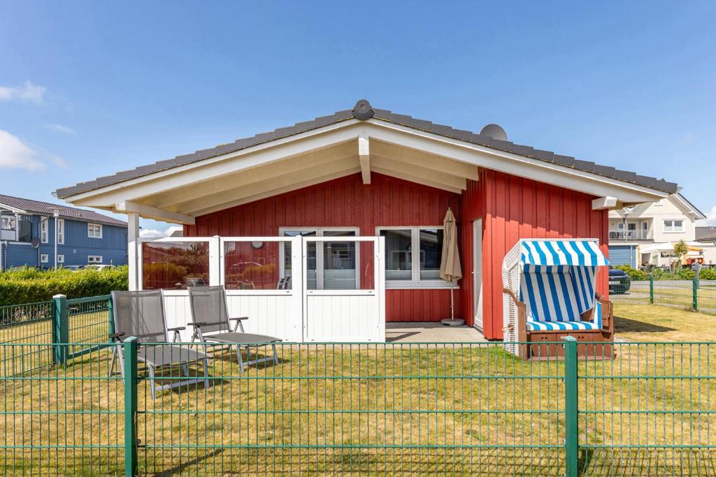 a red house with two chairs in front of it at Ferienhaus - Sylt in Dagebüll