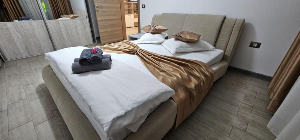 two beds in a hotel room with shoes on them at Mamaia Nord Promenada - Beach Pool si Spa Resort langa plaja in Mamaia Nord