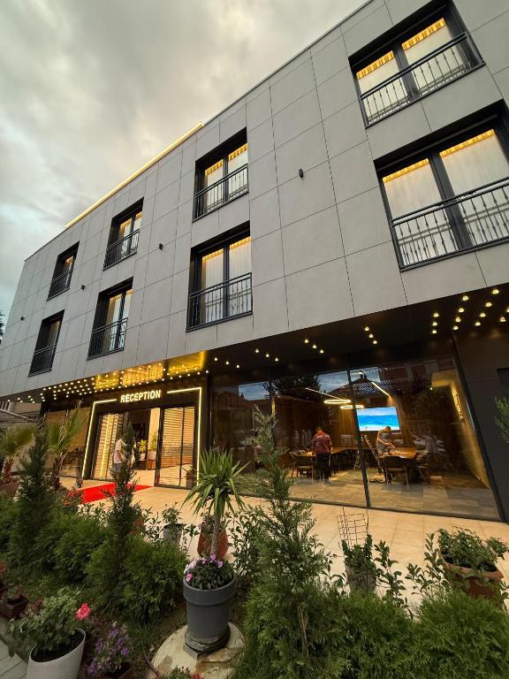 GjakoveにあるHotel Ari Gjakoveの植物が目の前に植えられた中庭のある建物