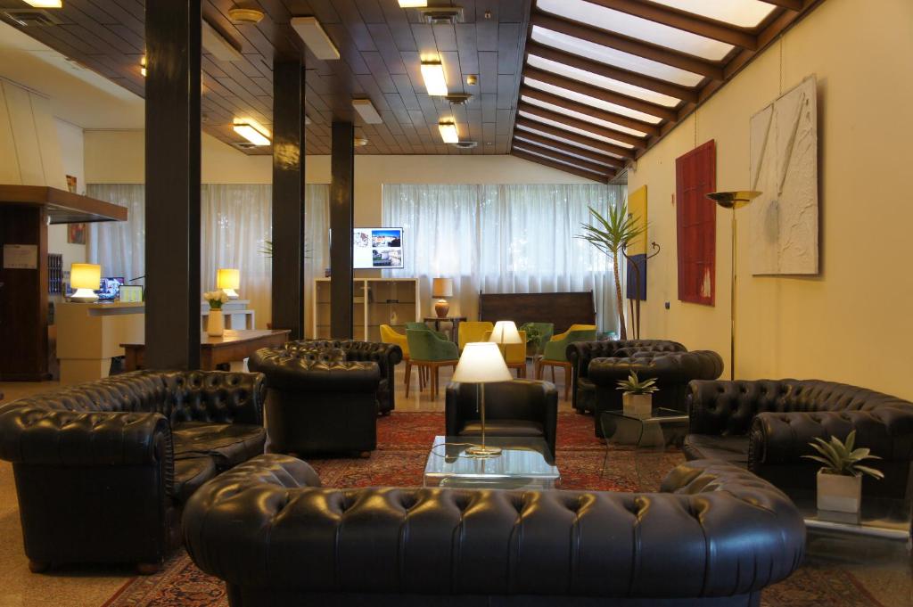 a lobby with leather couches and chairs and a living room at Hotel Al Sant'Andrea in Sarzana