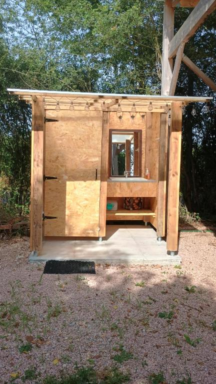 Un gran cobertizo de madera con un espejo dentro. en Caravane, en Saligny-sur-Roudon